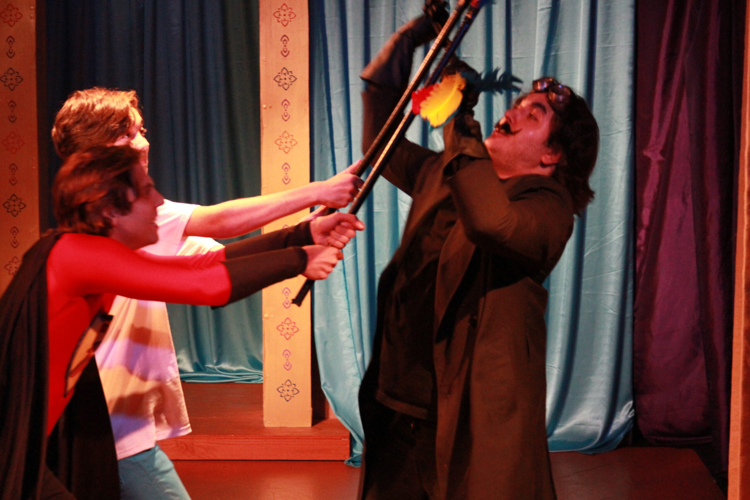 Inky (Scott Sharma) and Blackjack (Jase Lindgren) engage Sorcerer Slurm (Mark Lopez) in a Terrible Tickler duel in the World Premiere of Super Sidekick: The Musical, presented by Theatre Unleashed at The Sherry Theater in North Hollywood, CA